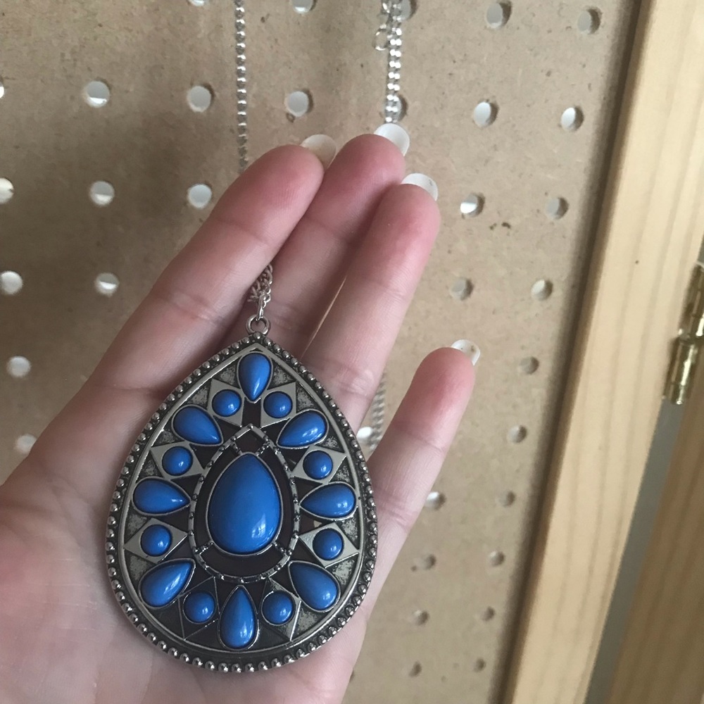 Long necklace w/large cornflower blue medallion.